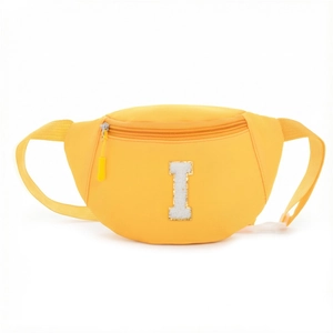 Close-up of vibrant yellow nylon waist bag with white letter I chenille patch detail