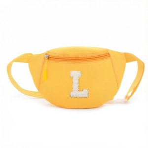 Detail of yellow nylon waist bag with a white plush L patch and gold sequins
