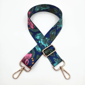 Close-up of floral bag strap with pink flowers and gold metal swivel snap hooks