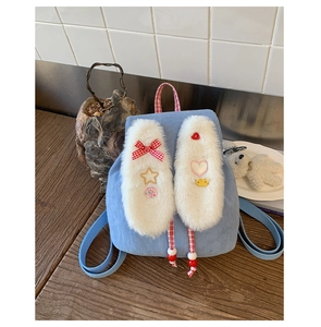 Detail of light blue corduroy kids backpack with plush rabbit ears and cute accessories