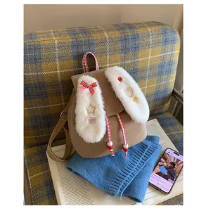 Detail of plush bunny ears and red checkered bow on brown corduroy kids backpack
