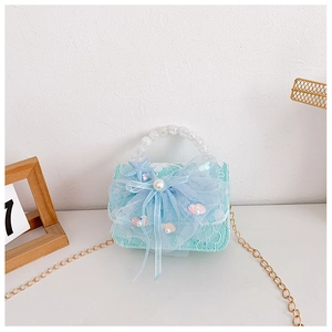 Detail of mint green girl handbag with lace, blue bow, pearls and starfish charms