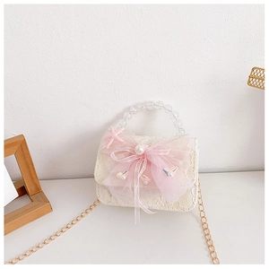 Detail of children's lace bag with pink mesh bow, large pearl, and beaded handle strap