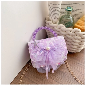 Close-up of purple lace girls purse with pearls, bow, and sparkling starfish charms