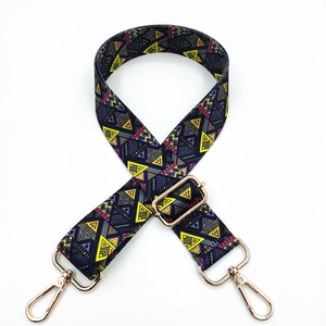 Detail of colorful geometric canvas bag strap with golden metal swivel hooks and buckles