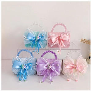 Detail of colorful lace children bags with satin bows and pearl handles in five pastel tones