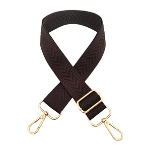 Close-up of brown chevron pattern bag strap with adjustable gold-tone metal hardware