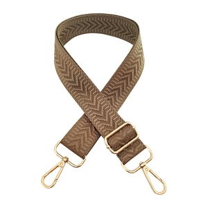 Detail of khaki woven arrow pattern bag strap with gold lobster clasps and metal slider