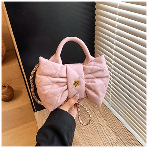 Close-up of pink quilted crossbody bag for kids featuring a bow and gold flower charm