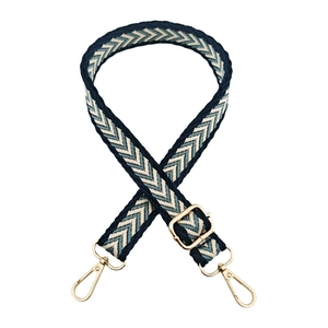 Close-up of jacquard woven strap with chevron pattern and gold metal swivel snap hooks