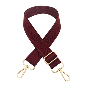 Detail of adjustable burgundy herringbone woven strap with gold metal buckles and clips