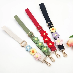 Detail of colorful knitted floral shoulder straps with adjustable gold lobster clasps