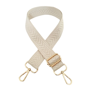 Detail of adjustable cream arrow weave bag strap with premium gold swivel lobster clasps