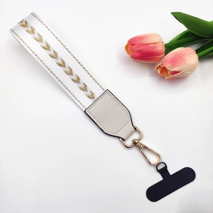 Detail of white woven wrist strap with gold chevron pattern and metal spring clasp