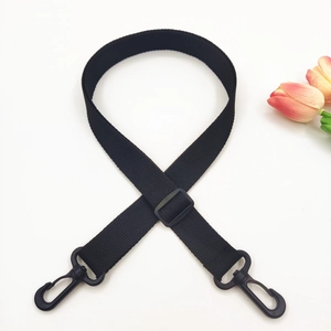 Close-up of black adjustable canvas bag strap with swivel hooks and durable plastic buckle