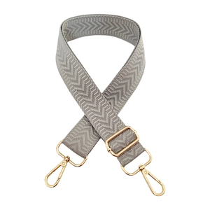 Detail view of grey herringbone woven bag strap with adjustable gold lobster clasps