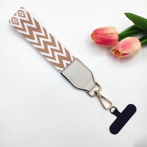Close-up of woven phone wrist strap with white leather connector and gold snap hook