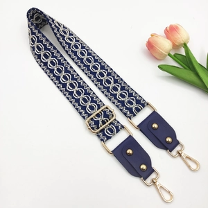 Detail of adjustable blue geometric jacquard strap with gold lobster clasps and PU leather