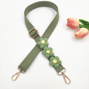 Close-up of avocado green wide fabric bag strap with handmade 3D floral decorations
