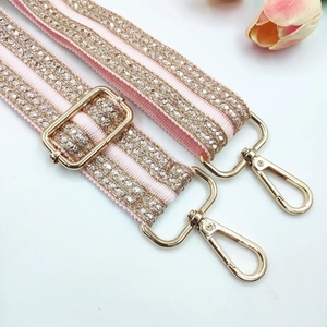 Detail of pink embroidered strap with glittering sequins and gold metal lobster clasps