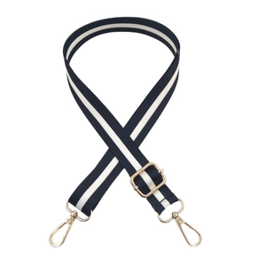 Adjustable black and white striped bag strap with gold metal hooks for cross-body use