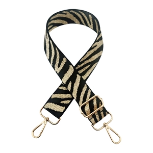 Close-up of zebra pattern wide strap with gold-tone swivel hooks and adjustable buckle