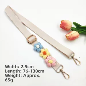 Detail of adjustable beige woven strap with colorful crochet flowers and gold hardware