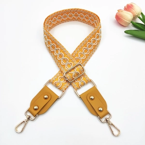 Close-up of bohemian yellow jacquard woven strap with rivets and gold metal hardware
