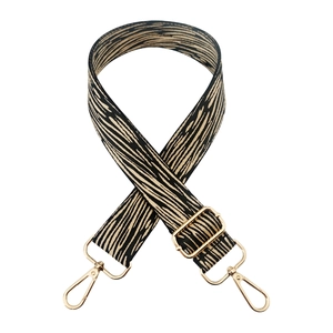 Close-up of zebra pattern wide bag strap with gold metal swivel hooks and adjustable buckle