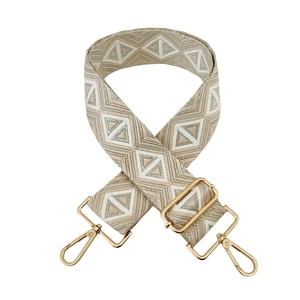 Detail of bohemian jacquard bag strap with geometric patterns and golden metal buckles