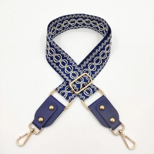 Detail of blue and silver geometric jacquard strap with gold swivel hooks and leather ends