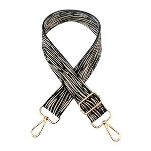 Detail of adjustable zebra stripe bag strap with premium gold metal swivel hooks