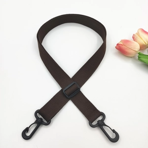 Detail of a dark brown adjustable canvas strap with durable black plastic swivel hooks