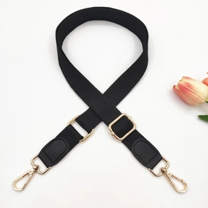 Adjustable black cotton canvas bag strap with leather ends and gold metal hardware