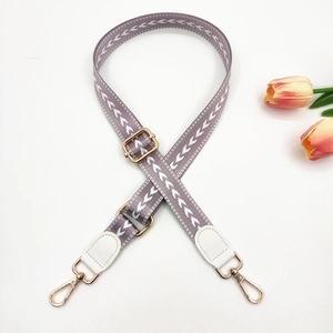 Close-up of adjustable purple and grey arrow pattern bag strap with gold metal lobster hooks