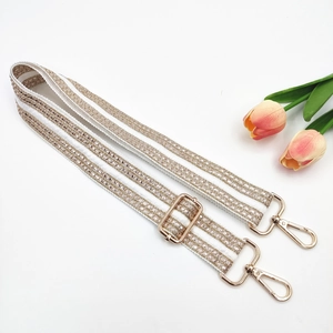 Close-up of ethnic style wide strap with gold sequins, tulips and metal hooks
