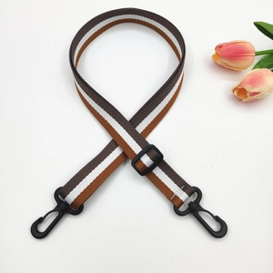 Close-up of adjustable striped bag strap with plastic hooks and durable nylon texture
