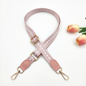 Adjustable mauve strap for bags with white arrow weave pattern and gold hardware hooks