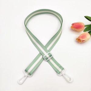 Detail of adjustable pale green striped strap with white plastic buckle and tulip decor