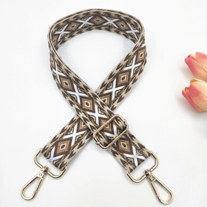 Macro detail of 3.8cm ethnic crossbody strap with embroidered geometric diamond patterns