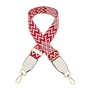 Detailed macro of red and white wave pattern woven strap with gold metal hardware