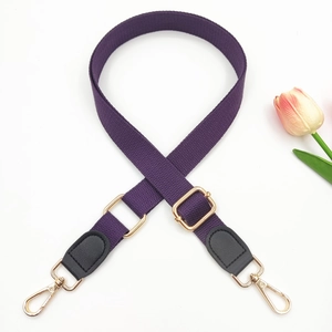 Close-up of adjustable purple woven strap with gold metal buckles and leather reinforcement