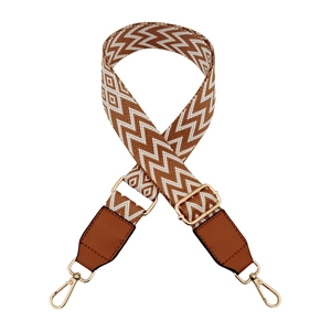 Close-up of adjustable wave pattern bag strap with leather ends and gold metal hooks