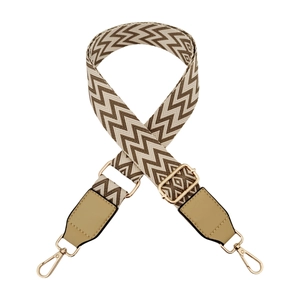 Detail of adjustable wave pattern canvas shoulder strap with leather ends and gold hardware