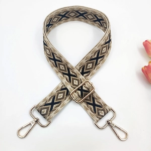 Detail of bohemian style 3.8cm wide bag strap with black geometric embroidery on beige