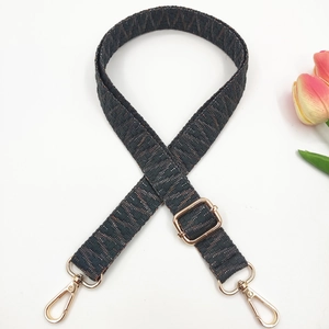 Detail of woven geometric replacement strap with gold metal hooks and slider