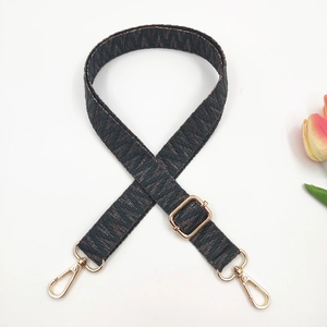 Close-up of woven ethnic bag strap with geometric jacquard and gold metal buckles
