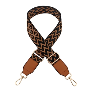 Close-up of adjustable wave pattern bag strap with leather ends and golden metal hardware