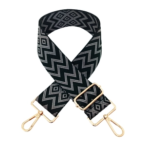 Close-up of 5cm wide adjustable bag strap with geometric wave pattern and gold hardware