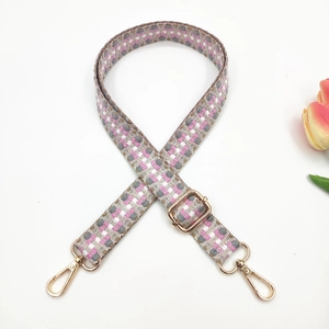 Ethnic woven bag strap with pink and grey checkerboard pattern and gold metal hooks